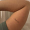 Small tattoo on a person's arm with the word 'keep going' against a neutral background