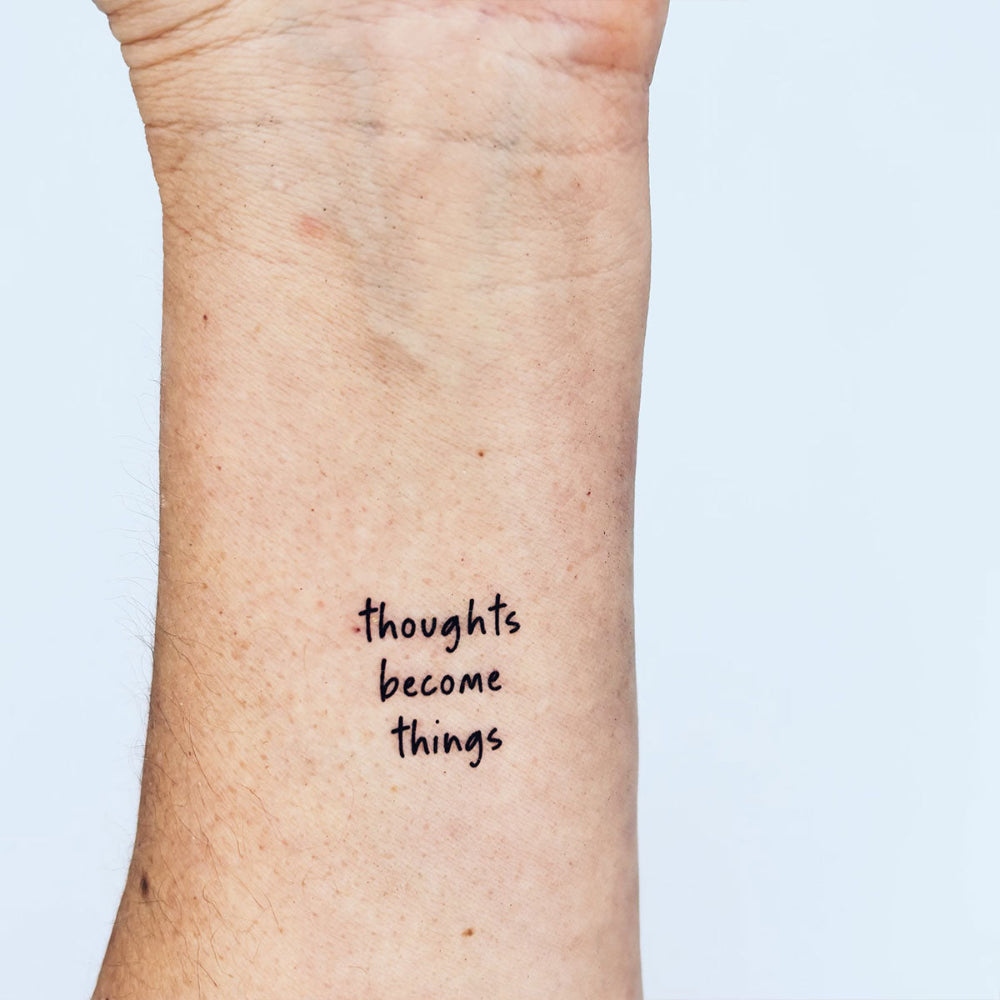 'Thoughts become things' quote tattoo in sleek black ink – inspiring forearm design for mindset and manifestation
