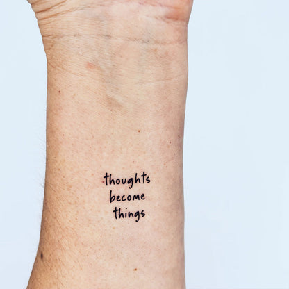 'Thoughts become things' quote tattoo in sleek black ink – inspiring forearm design for mindset and manifestation