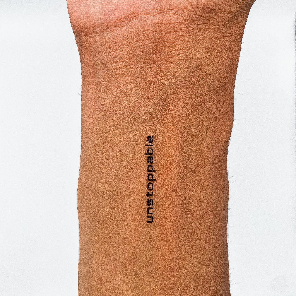 'unstoppable' minimalist quote tattoo by MotivInk – bold black motivational temporary tattoo on forearm