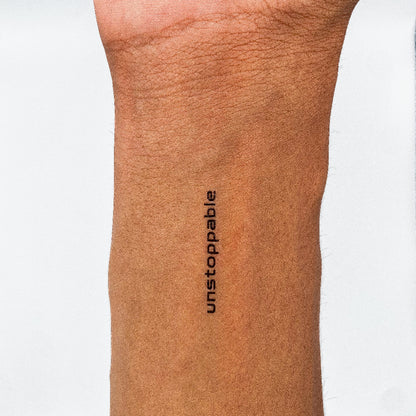 'unstoppable' minimalist quote tattoo by MotivInk – bold black motivational temporary tattoo on forearm