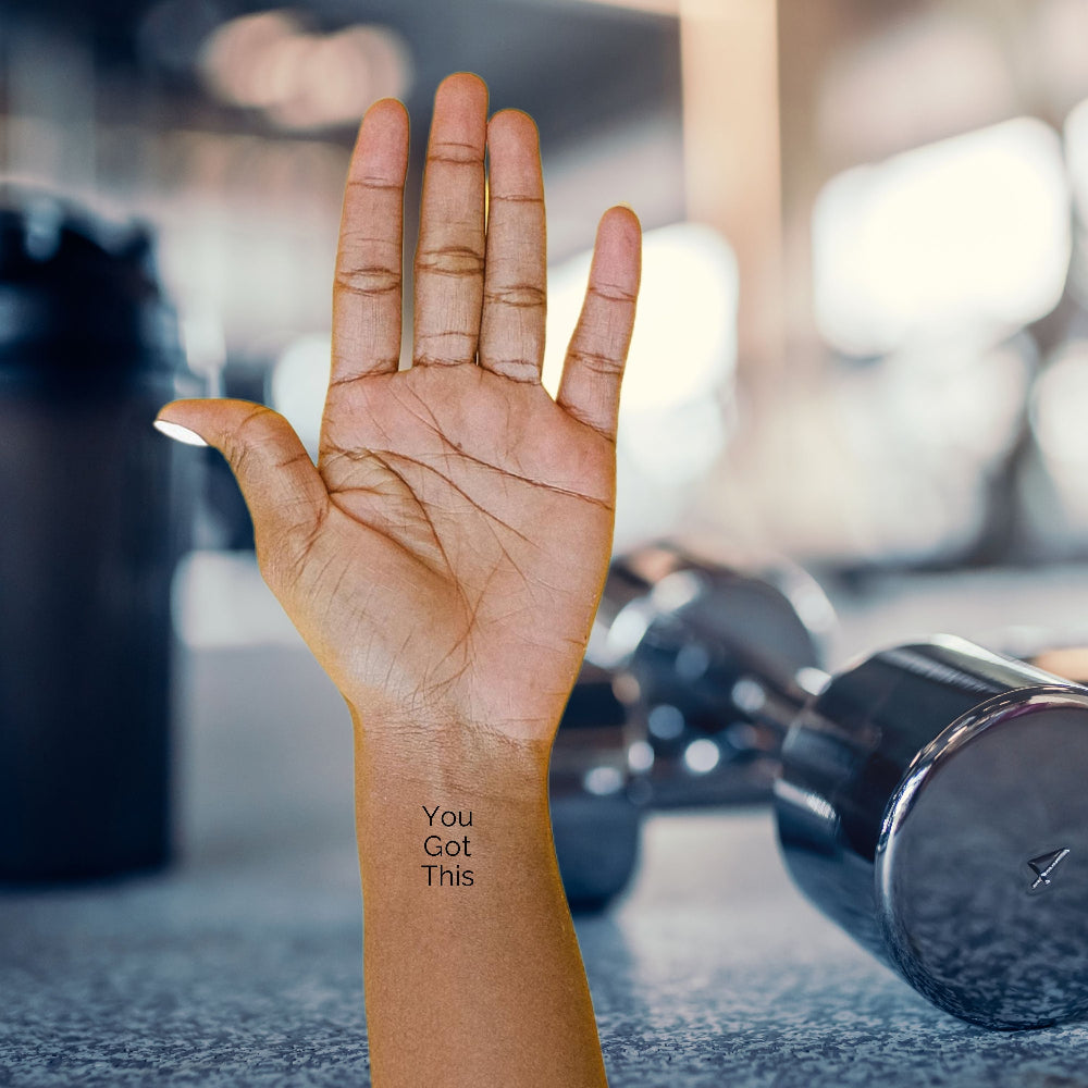 'You Got This' empowering temporary tattoo on wrist – minimalist black ink motivational quote by Motivink in fitness gym setting