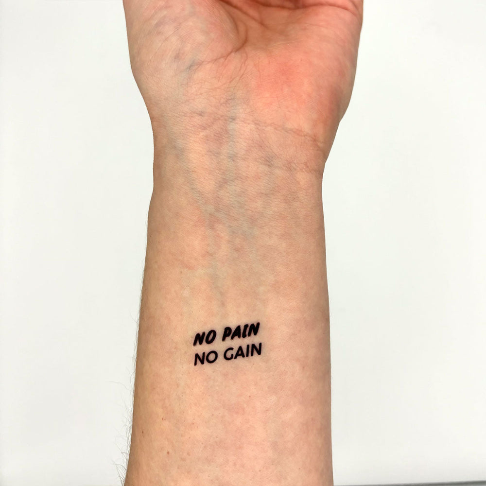 No Pain No Gain motivational temporary tattoo on inner forearm, minimalist black ink design for strength and hustle.