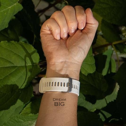 Dream BIG motivational temporary tattoo on inner wrist with white watch and green leave background, minimalist design by Motivink.