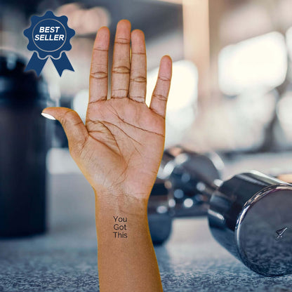 Hand with 'You Got This' tattoo near dumbbells in the gym, with a 'Best Seller' badge in the corner.