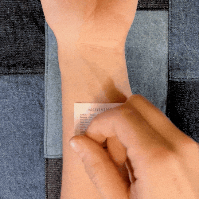 Applying 'Just Breathe' minimalist quote tattoo to wrist – temporary mindfulness and anxiety-relief design 
