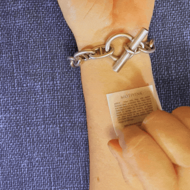 Applying 'Level Up' motivational wrist tattoo – empowering quote for goal setting and growth