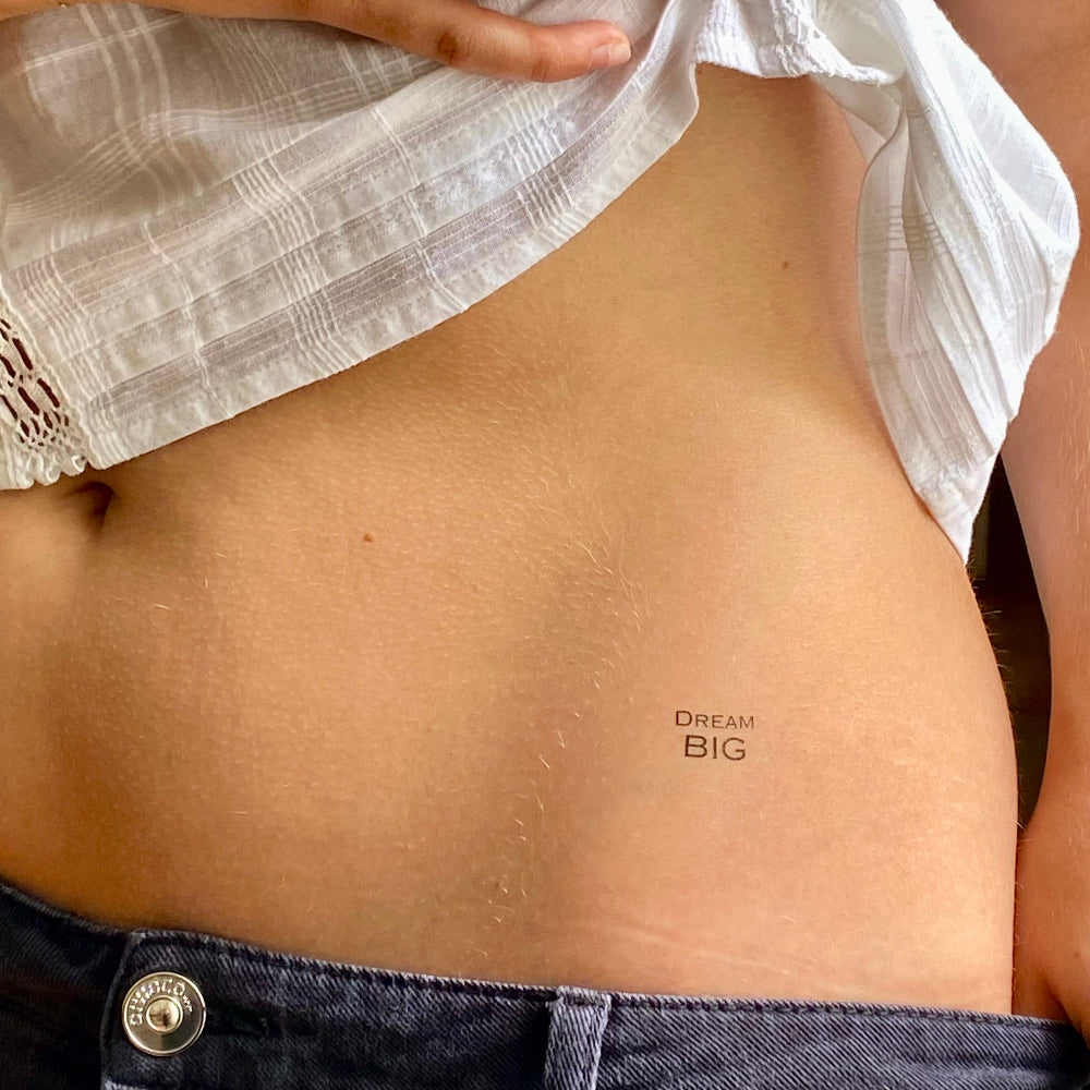 Dream BIG motivational temporary tattoo for visions and dreams placed on waist, minimalist design by Motivink.