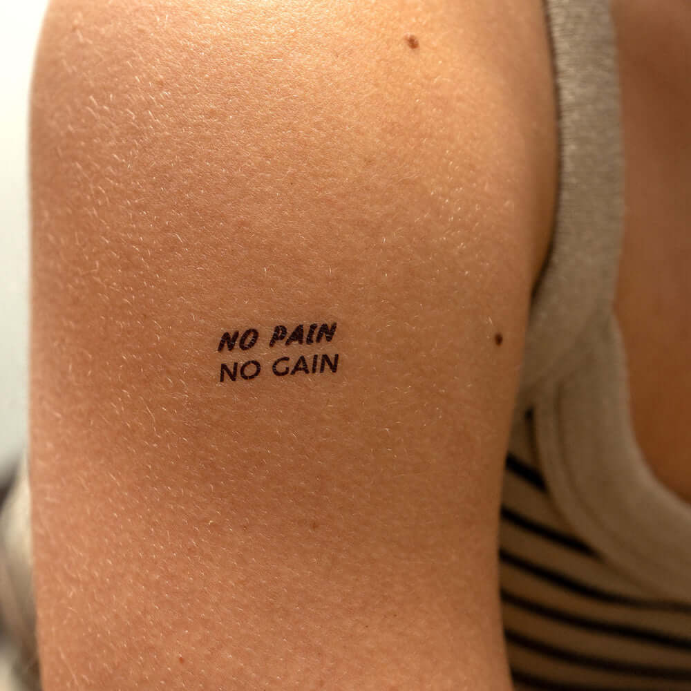 No Pain No Gain motivational temporary tattoo on upper arm, inspriational fitness quote in bold black ink by Motivink